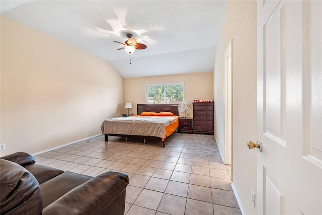 bedroom featuring light tile patterned flooring, vaulted ceiling, a textured ceiling, and baseboards