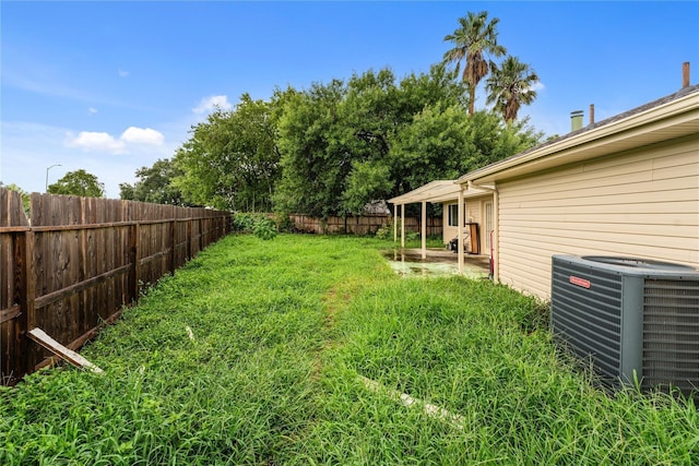 view of yard featuring central air condition unit, a patio area, and a fenced backyard