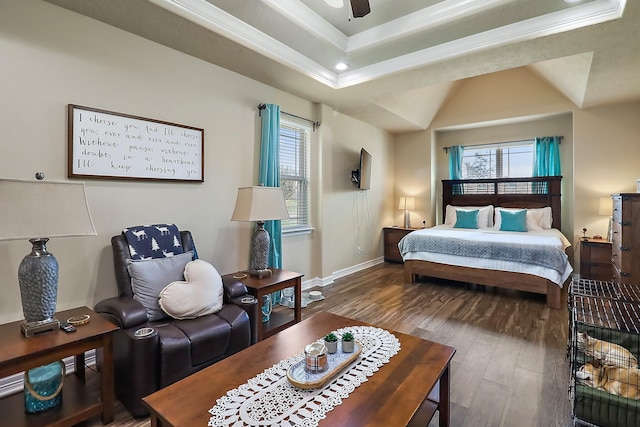 bedroom featuring a tray ceiling, ornamental molding, wood finished floors, and baseboards