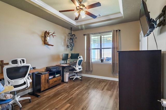 office with wood finished floors, a ceiling fan, visible vents, baseboards, and a raised ceiling