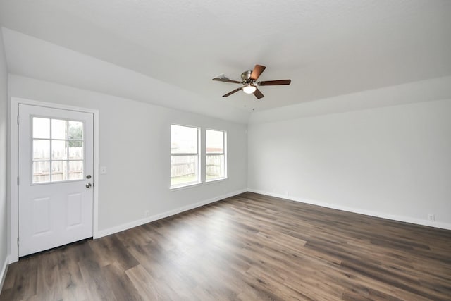 interior space featuring ceiling fan, dark wood-type flooring, and baseboards