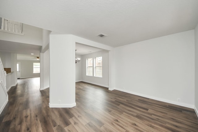 unfurnished room with baseboards, visible vents, dark wood-type flooring, and a wealth of natural light