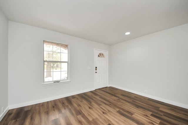 empty room with baseboards, dark wood-type flooring, and recessed lighting