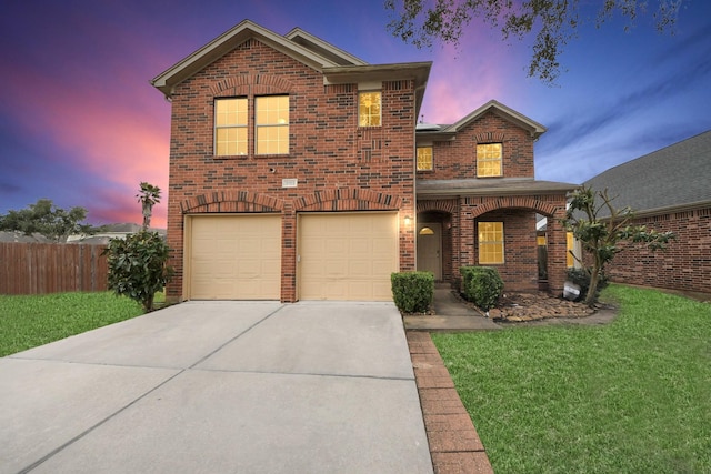 traditional home with driveway, an attached garage, fence, a front lawn, and brick siding