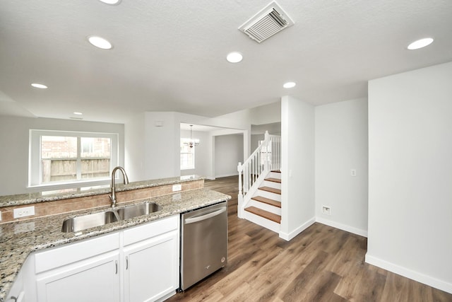 kitchen featuring light stone counters, a sink, visible vents, white cabinetry, and stainless steel dishwasher