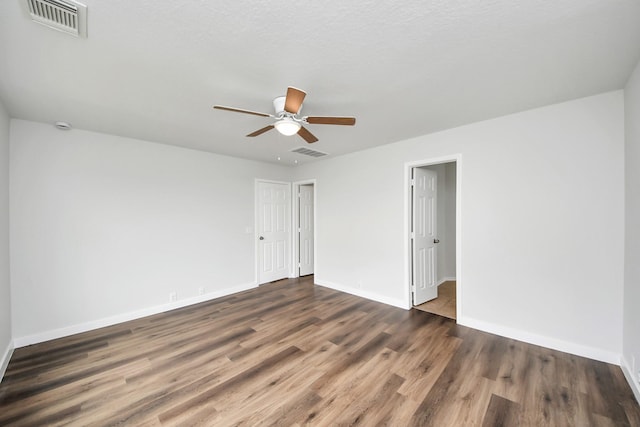 spare room with dark wood-style floors, baseboards, and visible vents