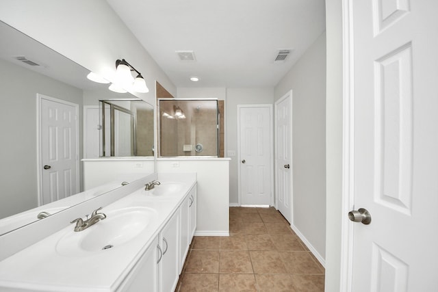 bathroom featuring tile patterned flooring, a sink, visible vents, and a shower stall