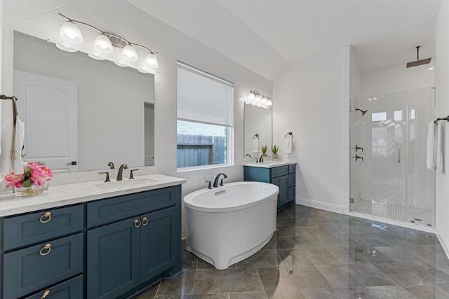 full bath featuring a freestanding bath, two vanities, a sink, and a shower stall