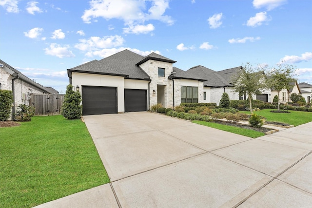 view of front facade featuring concrete driveway, stone siding, an attached garage, fence, and a front lawn