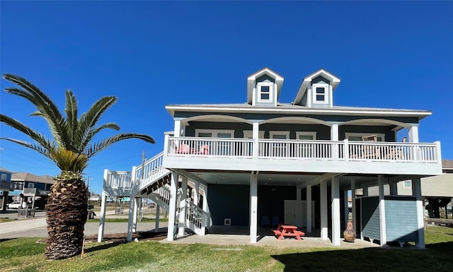 back of house with a carport, a yard, and stairway