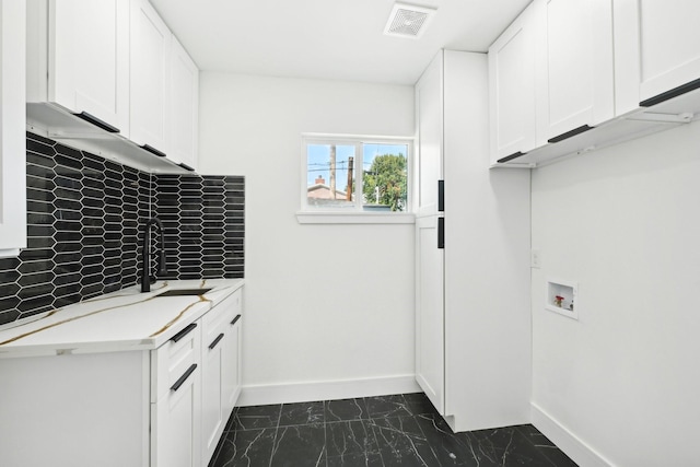 laundry area with marble finish floor, cabinet space, visible vents, a sink, and baseboards