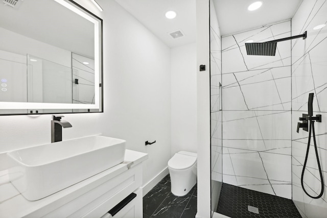 full bathroom featuring marble finish floor, a marble finish shower, toilet, vanity, and baseboards