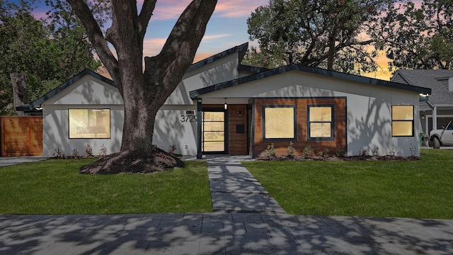 view of front of house with a front lawn and fence