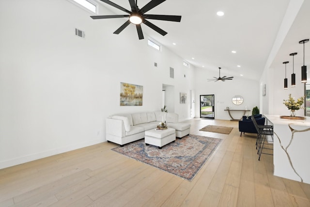 living area featuring ceiling fan, recessed lighting, a towering ceiling, visible vents, and light wood finished floors