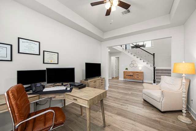 office area featuring ceiling fan, a tray ceiling, visible vents, and light wood-style floors