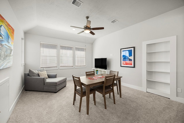 dining area with light carpet, visible vents, and lofted ceiling