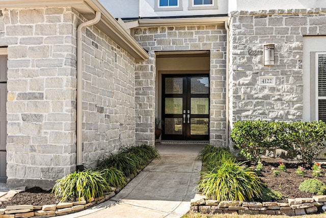 entrance to property featuring stone siding and french doors