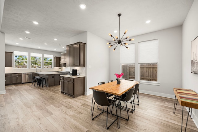 dining room featuring recessed lighting, light wood-style flooring, baseboards, and an inviting chandelier