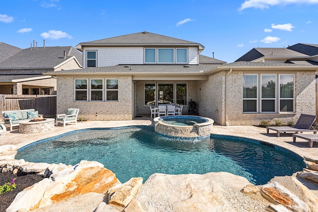 view of pool with an outdoor fire pit, a pool with connected hot tub, a patio, and fence