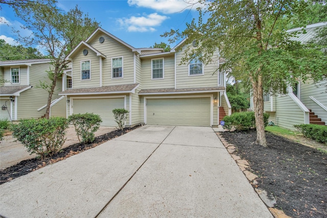 view of front of property featuring a shingled roof, concrete driveway, an attached garage, and stairs