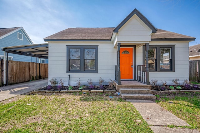 bungalow featuring a front yard, concrete driveway, and fence