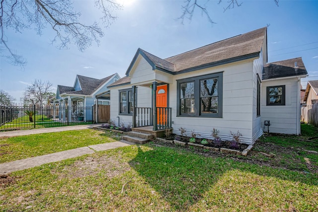 bungalow-style house featuring fence and a front yard