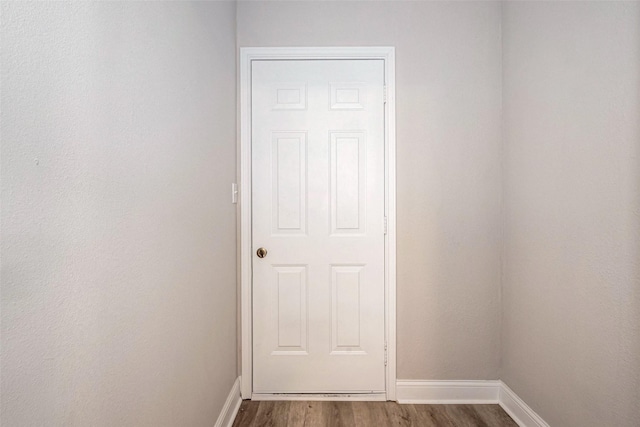 doorway with baseboards and wood finished floors