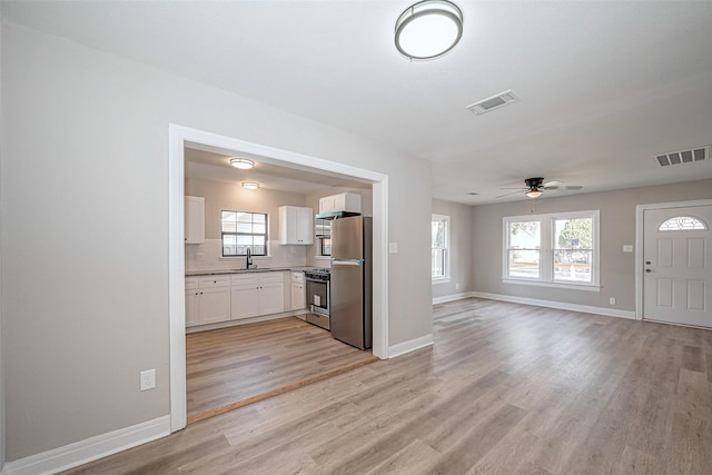 kitchen featuring visible vents, appliances with stainless steel finishes, white cabinets, and open floor plan