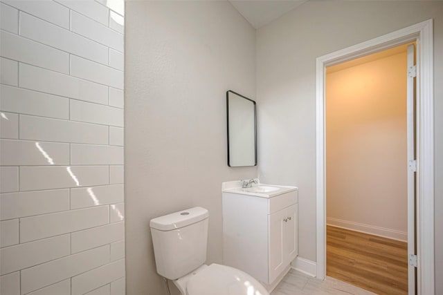 full bathroom featuring baseboards, vanity, toilet, and wood finished floors