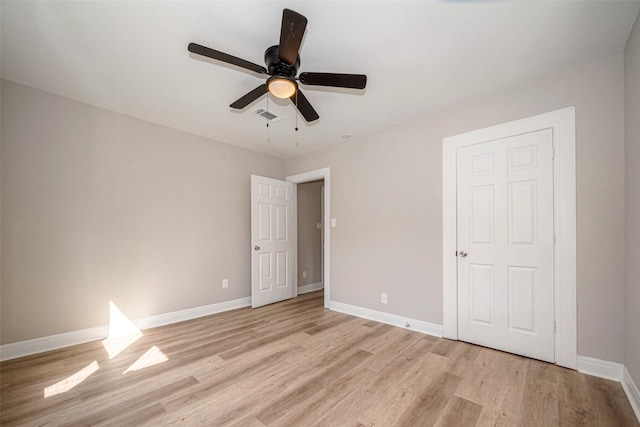 unfurnished bedroom featuring light wood-style floors, visible vents, baseboards, and a ceiling fan