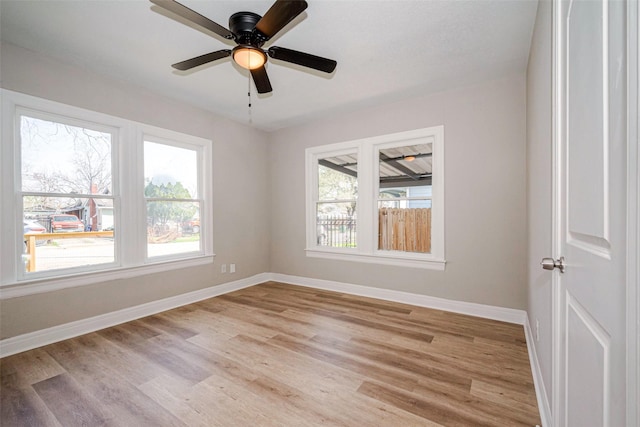 unfurnished room with ceiling fan, light wood-type flooring, and baseboards