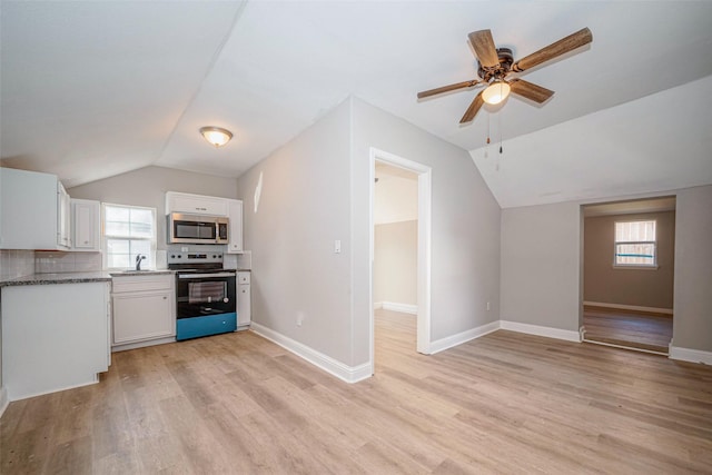 kitchen with light wood finished floors, appliances with stainless steel finishes, and white cabinets