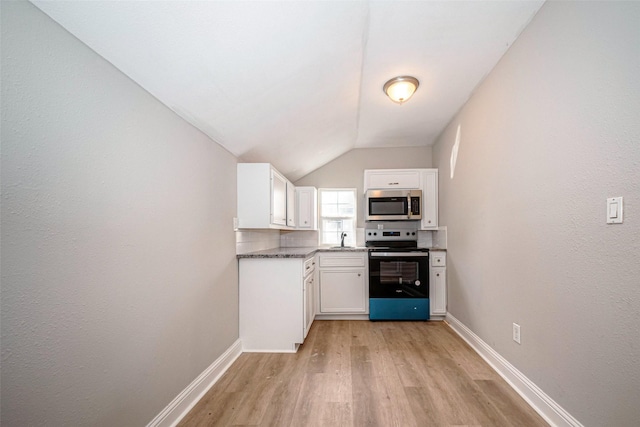 kitchen with electric range, a sink, white cabinetry, stainless steel microwave, and dark countertops