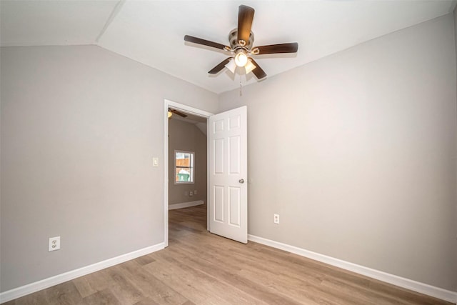 empty room featuring baseboards, vaulted ceiling, a ceiling fan, and light wood-style floors