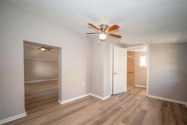 empty room featuring ceiling fan, baseboards, and wood finished floors