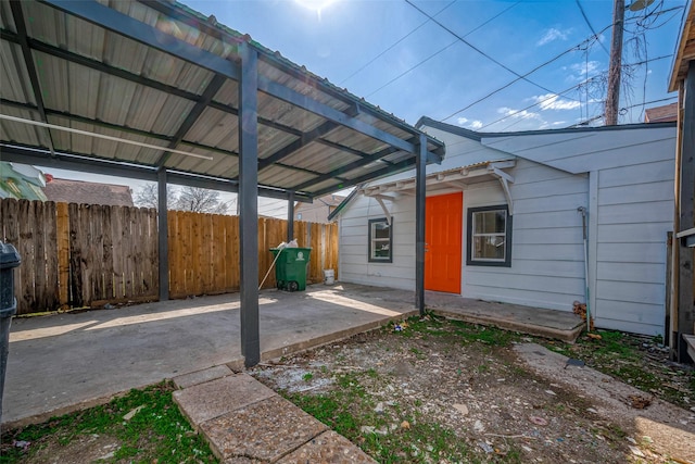 view of car parking with fence and a carport