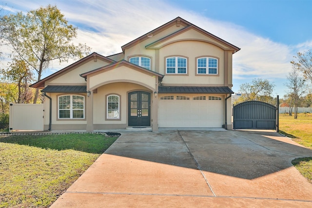 view of front of home with concrete driveway, a standing seam roof, a gate, and stucco siding