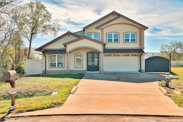 view of front of house with an attached garage, concrete driveway, a gate, stucco siding, and a standing seam roof