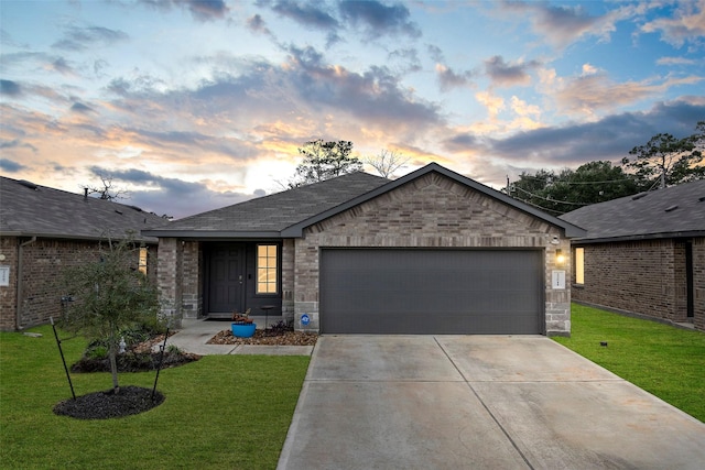 single story home featuring a front yard, brick siding, driveway, and an attached garage