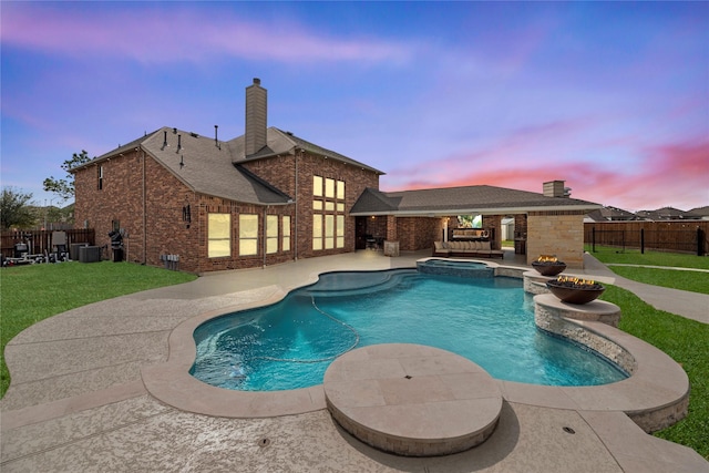 view of swimming pool with a patio, a fenced backyard, central air condition unit, a pool with connected hot tub, and a lawn