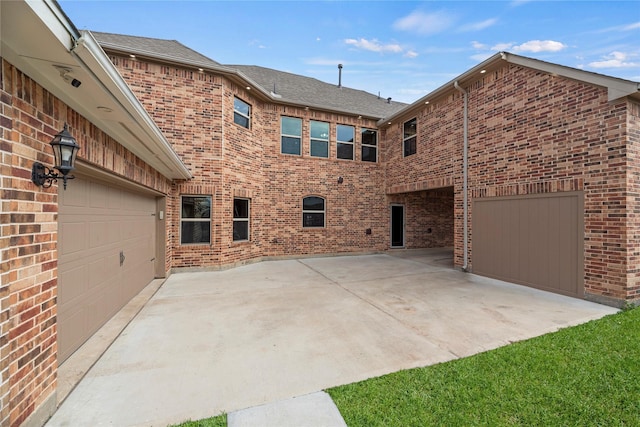 view of side of property featuring driveway and brick siding