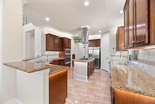 kitchen with a center island, appliances with stainless steel finishes, island range hood, light stone countertops, and a peninsula