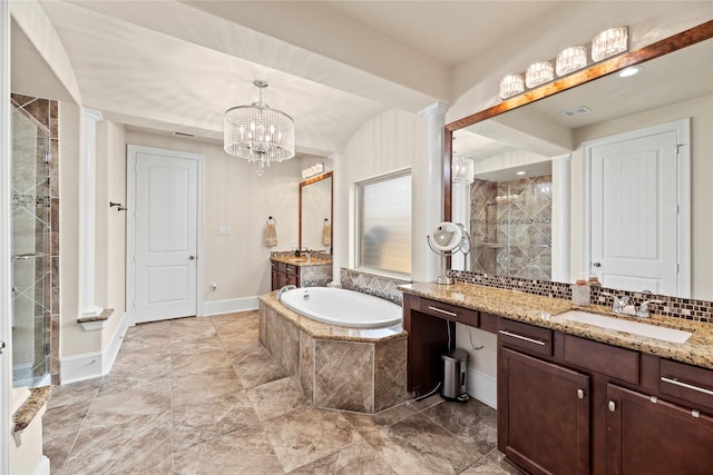 full bath featuring two vanities, a sink, a shower stall, a chandelier, and backsplash