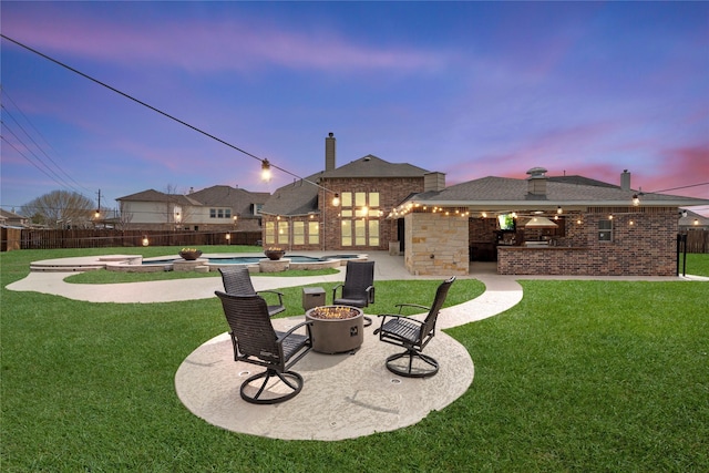 view of yard featuring a patio area, a pool with connected hot tub, fence, and a fire pit