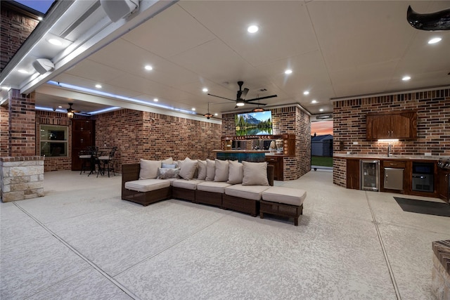 living room with beverage cooler, brick wall, ceiling fan, and recessed lighting