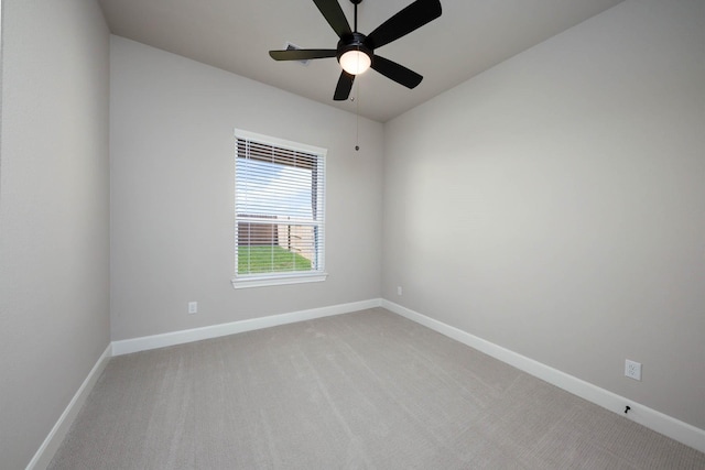 empty room featuring light carpet, baseboards, and a ceiling fan