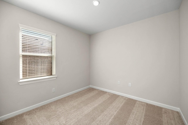 spare room featuring carpet and baseboards