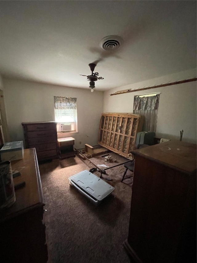 miscellaneous room with visible vents, dark colored carpet, and a ceiling fan