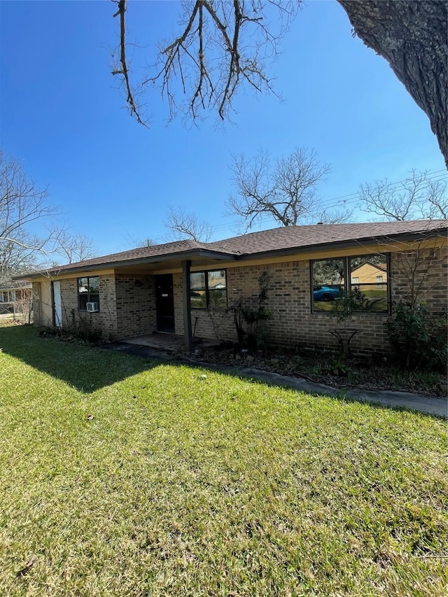 view of front of house featuring brick siding and a front lawn