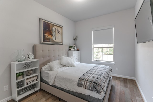 bedroom with baseboards and wood finished floors